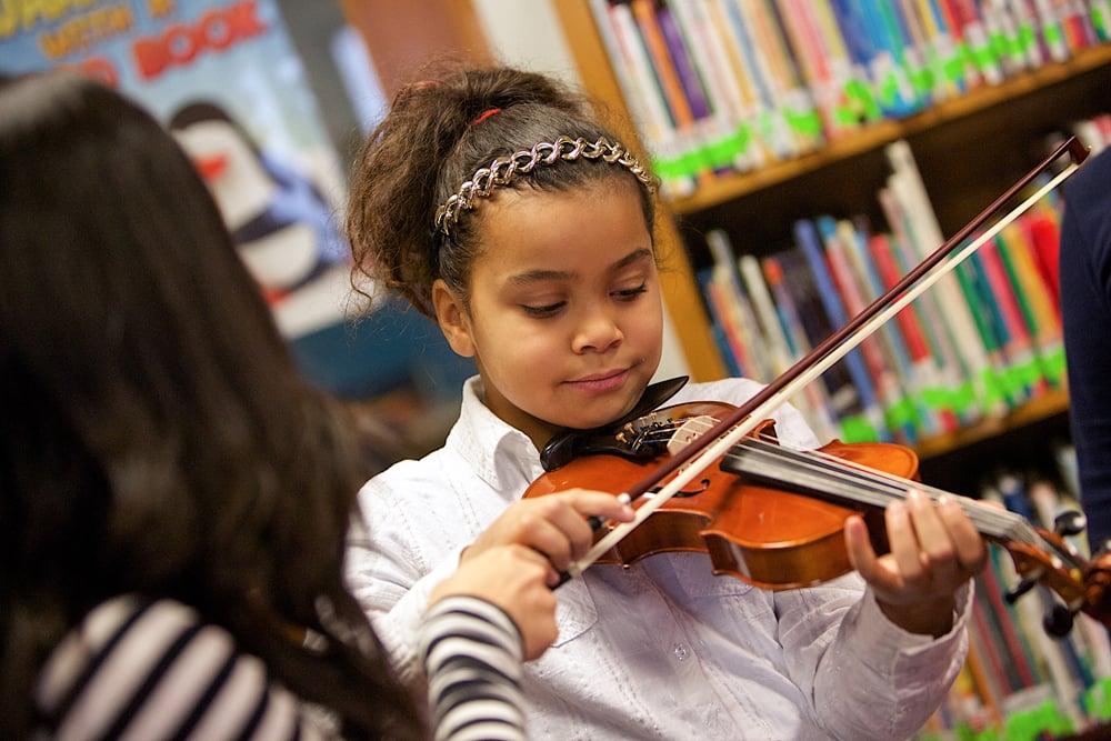 Young students learning with Grand Rapids Symphony musicians